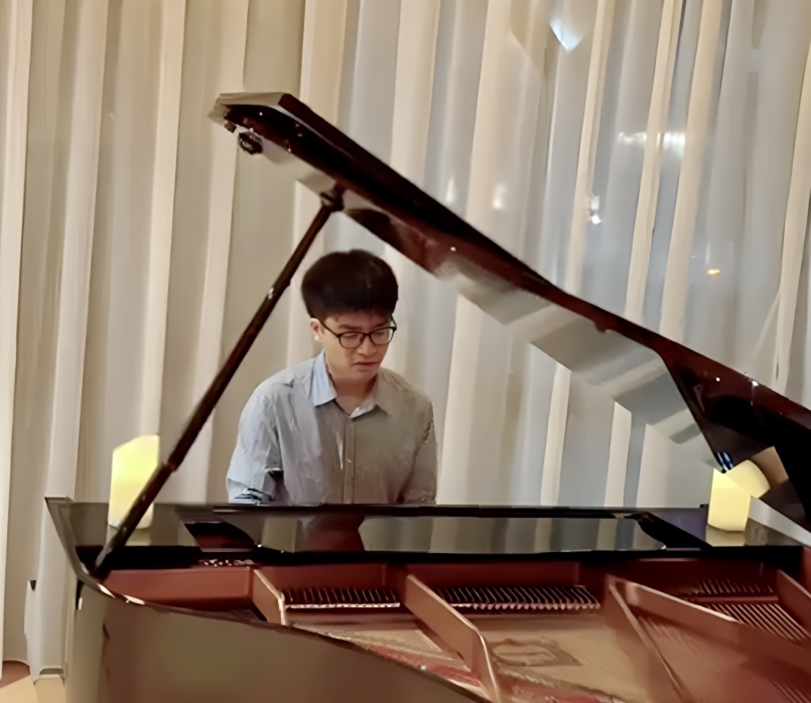 Jaeyong Kang playing a grand piano by candlelight