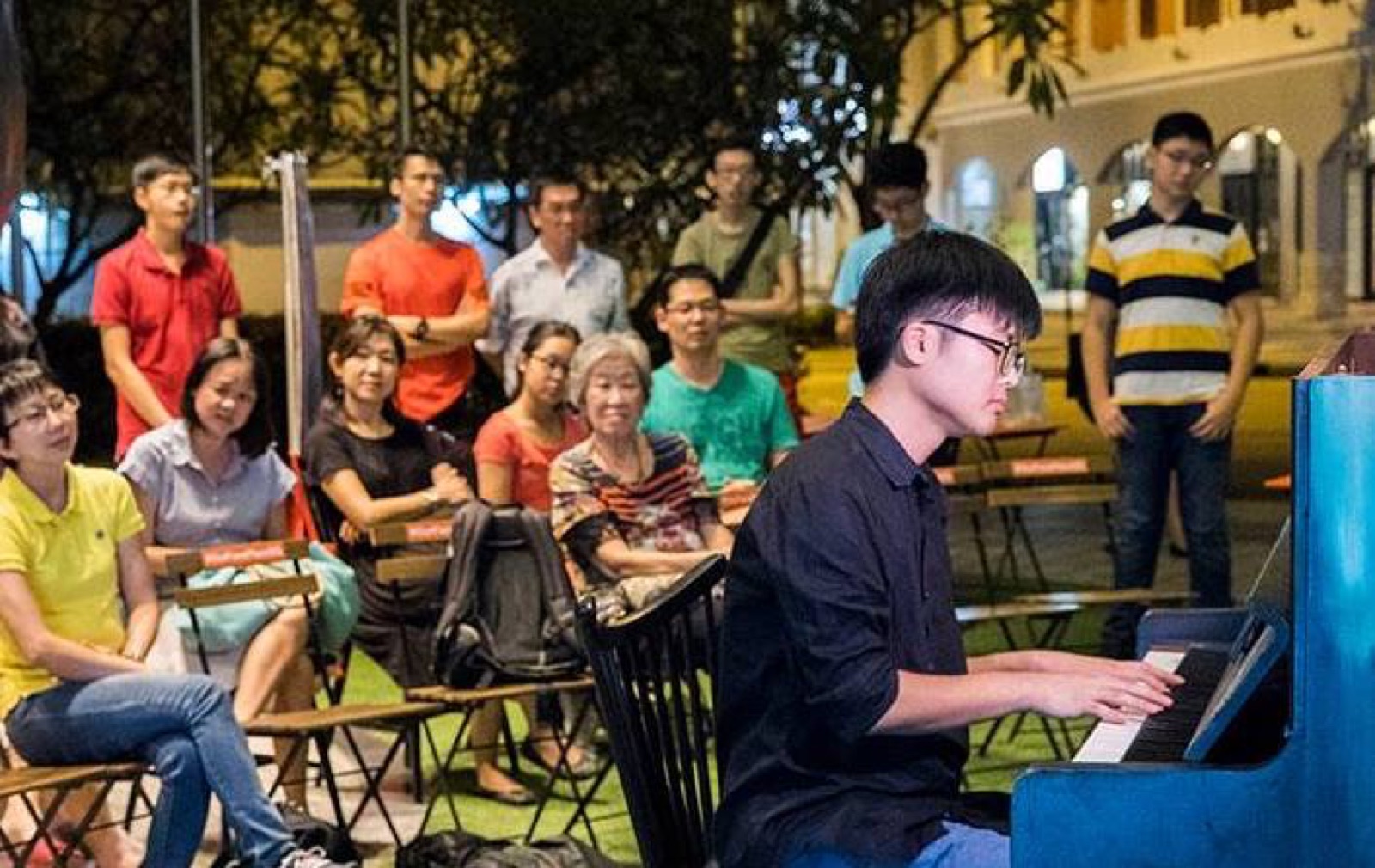 Jaeyong Kang playing a public piano outdoors for a seated audience