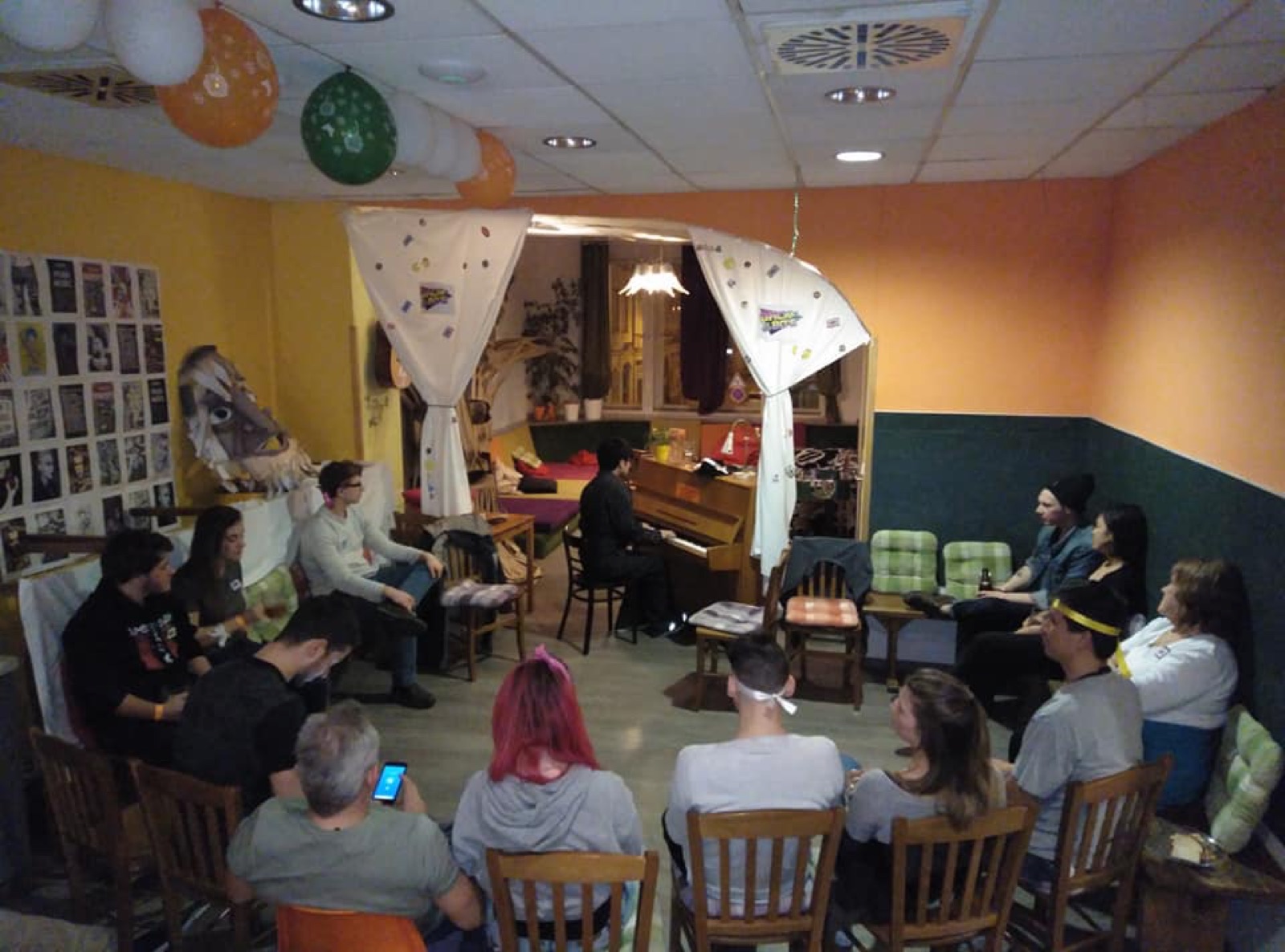 Jaeyong Kang playing an upright piano for a small gathered audience