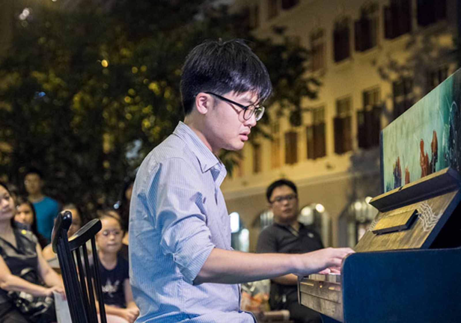 Jaeyong Kang playing a painted street piano at night
